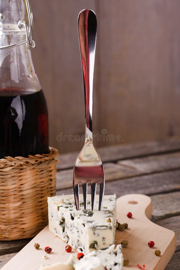 Blue cheese with single fork next to red wine stock photos Blue cheese with single fork next to red wine stock photos