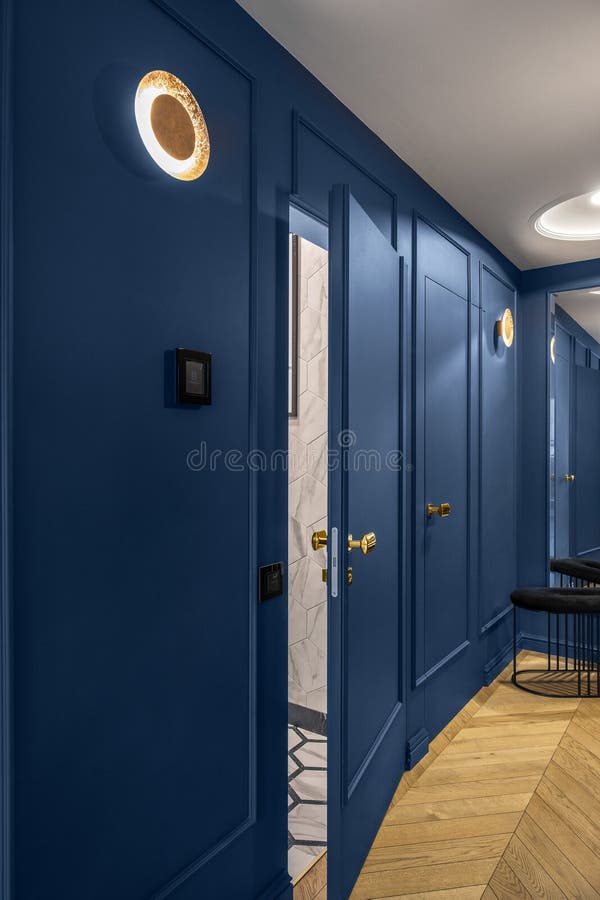 Blue classic wall decor in modern interior with golden line decor elements, wooden floor, hidden doors. stock photography