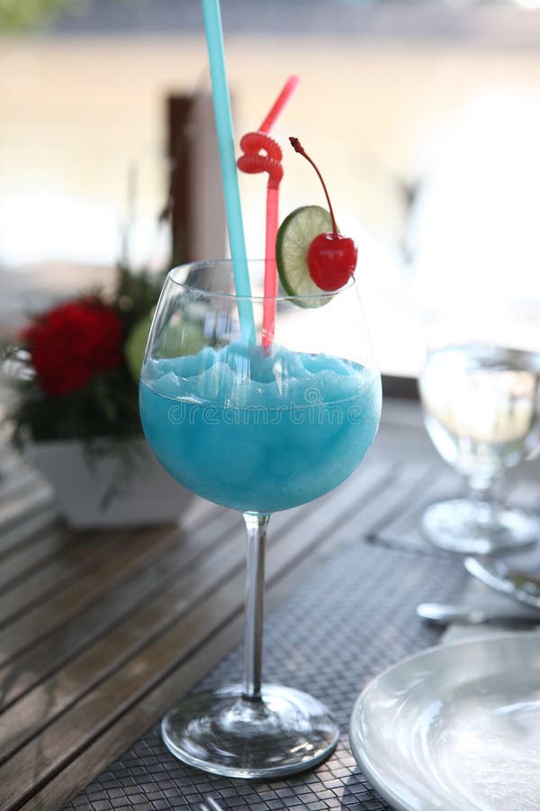 Blue cocktail with cherry and lime , kamikaze