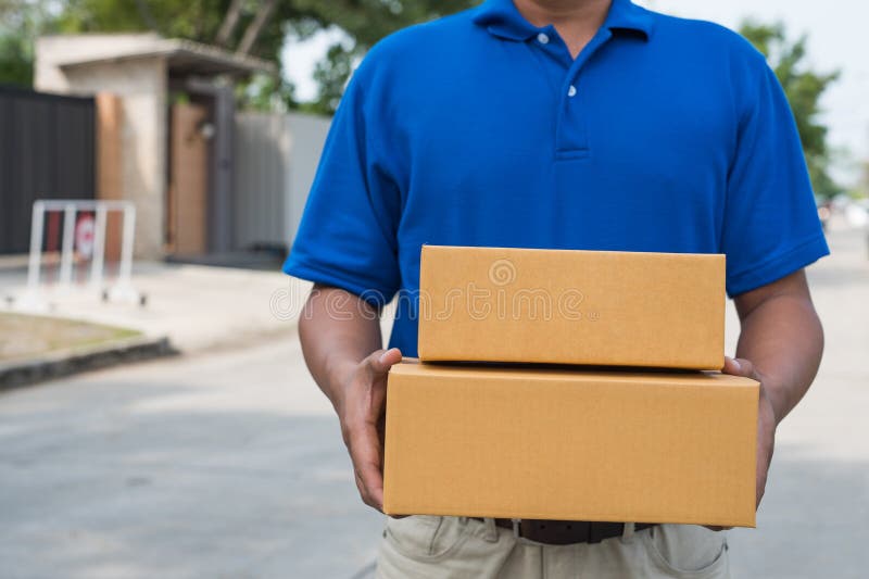 Blue Delivery man που κρατά κουτί από χαρτόνι στοκ φωτογραφίες