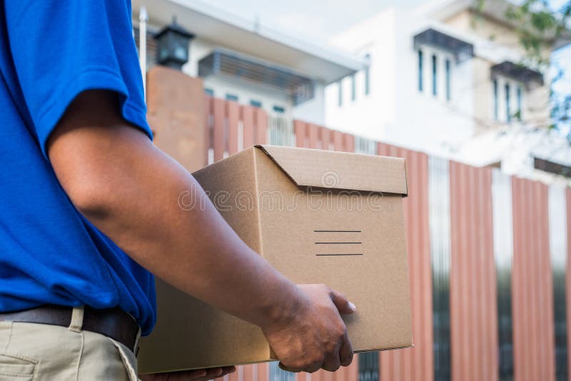 Blue Delivery man που κρατά κουτί από χαρτόνι στοκ εικόνες με δικαίωμα ελεύθερης χρήσης