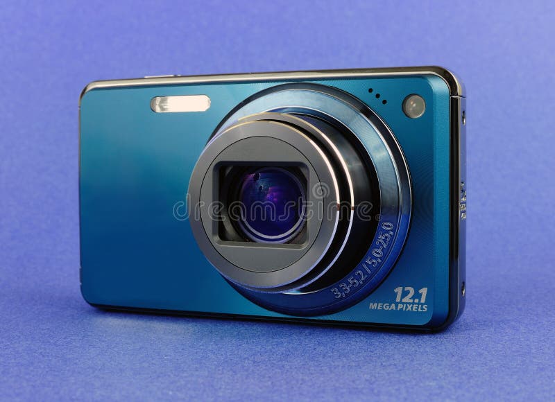 Stylish blue compact pocket digital camera over blue background. Stylish blue compact pocket digital camera over blue background