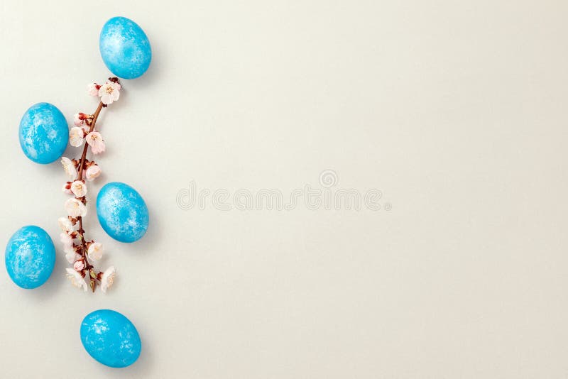 Blue easter eggs with apricot twig on silver textured paper. Top view. Copy space royalty free stock photography