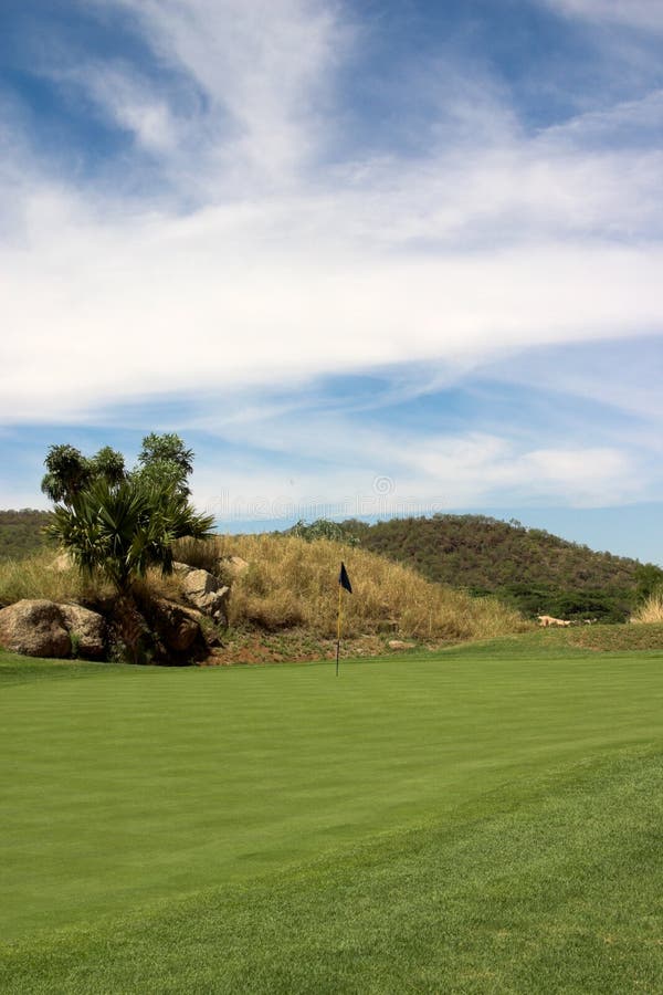 Blue flag in the hole on the green. Sunny day. Beautiful clouds. Day game drive stock images, royalty-free photos and pictures