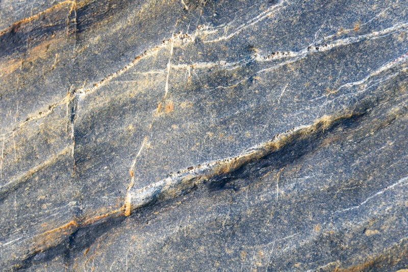 Blue gray stone with white and orange diagonal lines of pattern and texture as a nature background