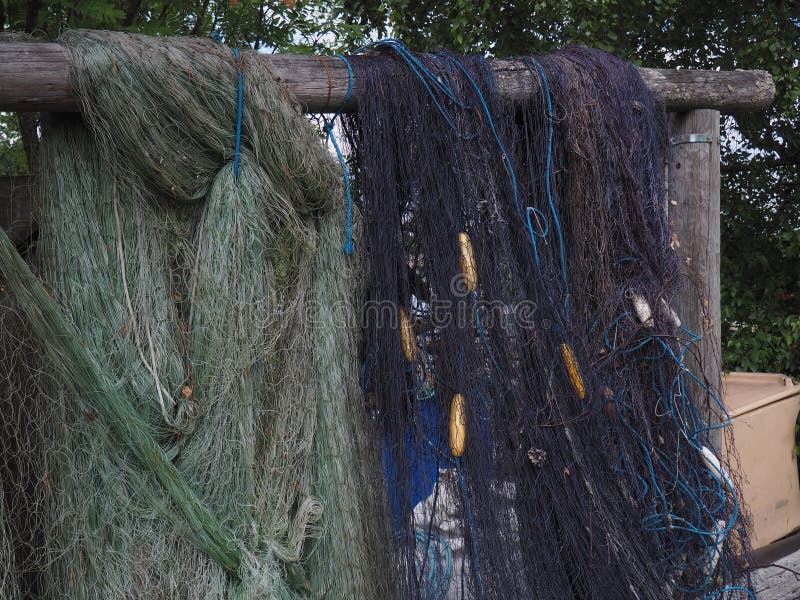 Blue and green fishing net hanged on a wooden stand