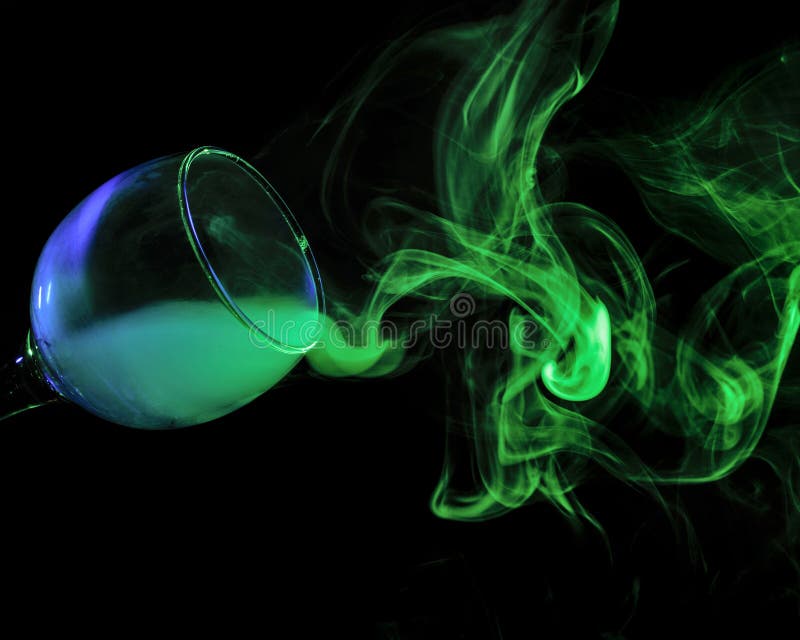 Abstract art. Hookah blue - green smoke in a cocktail glass on a white background. Witch potion background for Halloween. Unusual bar drink. Drink in the glass with the effect of dry ice. Abstract art. Hookah blue - green smoke in a cocktail glass on a white background. Witch potion background for Halloween. Unusual bar drink. Drink in the glass with the effect of dry ice.