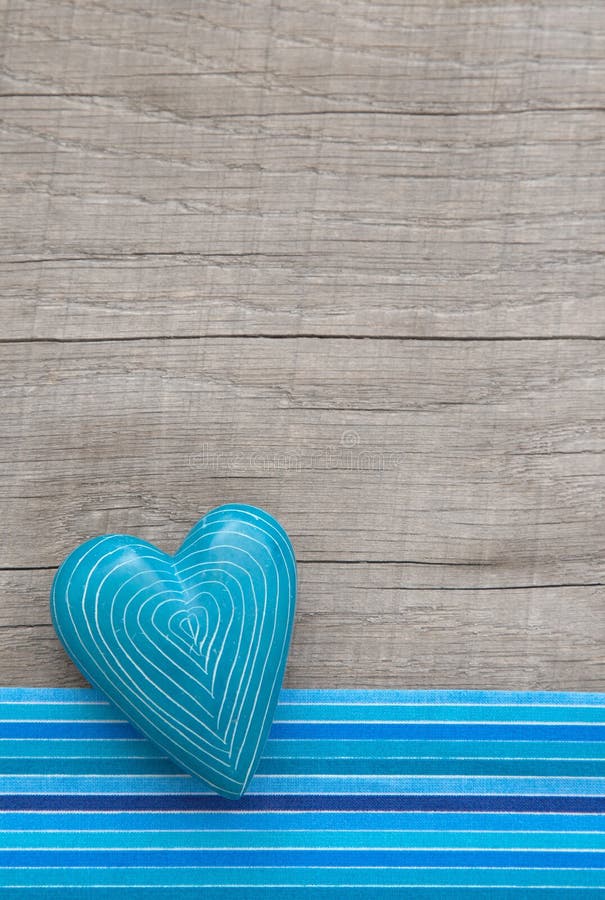 Blue heart with symmetric carved lines on grey wooden background royalty free stock photo Blue heart with symmetric carved lines on grey wooden background royalty free stock photo