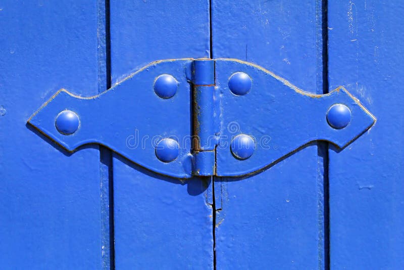 A brightly painted hinge on a wooden gate. A brightly painted hinge on a wooden gate