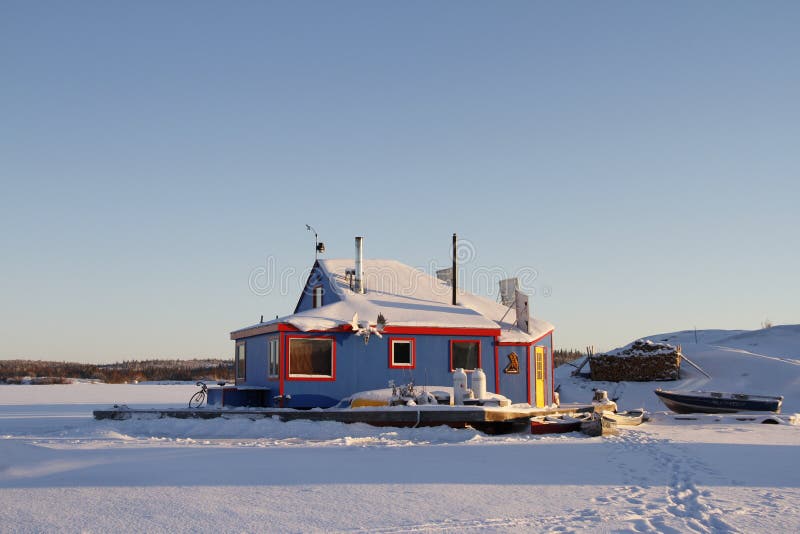 Blue houseboat on Yellowknife Bay in Great Slave Lake at sunset