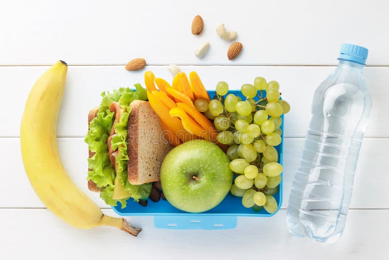 Blue lunch box with healthy food for school children with bottle of water on white wooden background.