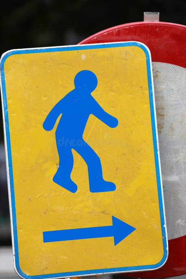 Blue Man on the Sign with Arrow in a Road Construction Site Stock Image