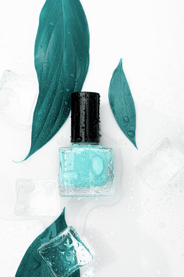 Blue nail polish bottle on white background. Cyan nail polish bottle with blue leaves and ice decor. Eco nail design