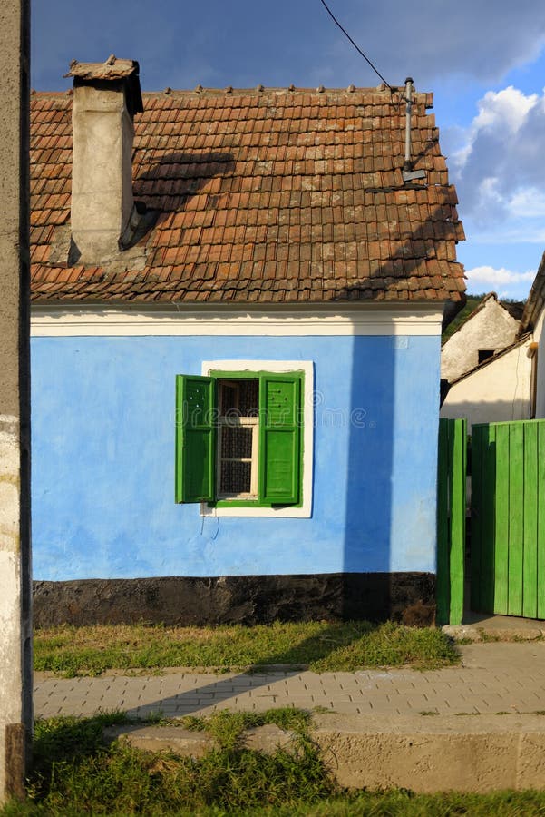 Blue painted house in Saxon Village, Transylvania, Romania. Blue painted house with red tile roof and green painted shutters and fence in old Saxon village in royalty free stock image Blue painted house in Saxon Village, Transylvania, Romania. Blue painted house with red tile roof and green painted shutters and fence in old Saxon village in royalty free stock image