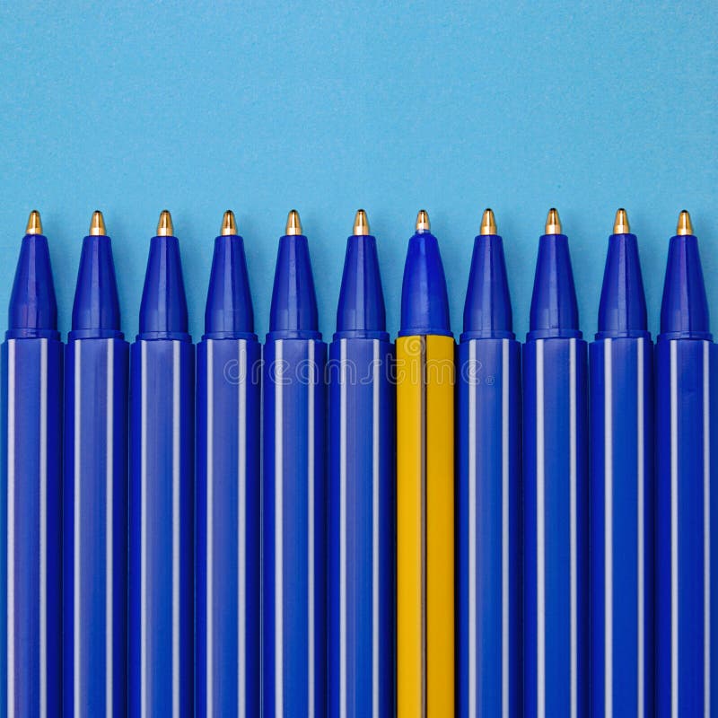 Blue pens and one different on blue background. Individuality concept. stock photography Blue pens and one different on blue background. Individuality concept. stock photography