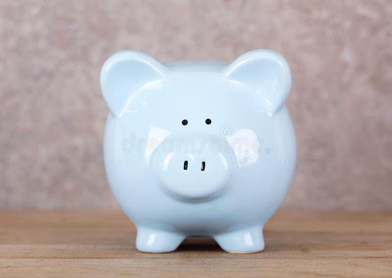 Blue piggy bank op tafel stock fotografie
