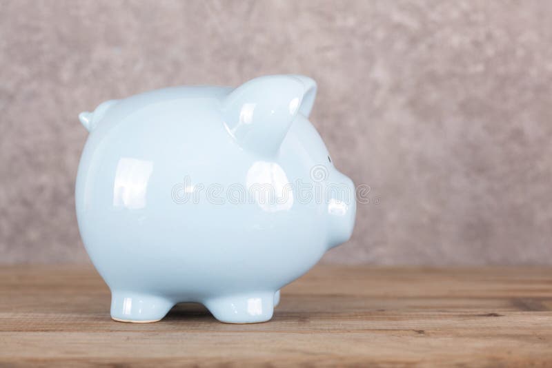Blue piggy bank op tafel stock afbeeldingen