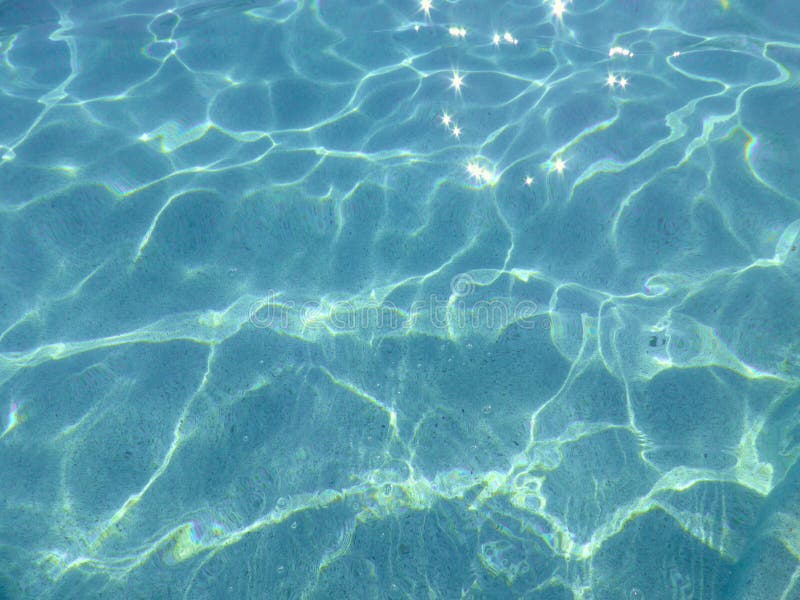 Blue pool water with sun reflections. stock photos