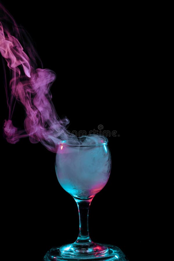 Abstract art. Hookah blue and Purple smoke in the cocktail glass on a white background. Witch potion background for Halloween. Unusual bar drink. Drink in the glass with the effect of dry ice. Abstract art. Hookah blue and Purple smoke in the cocktail glass on a white background. Witch potion background for Halloween. Unusual bar drink. Drink in the glass with the effect of dry ice.
