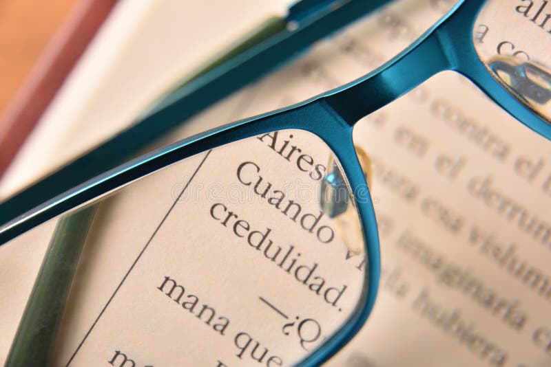 Blue reading glasses on open book close up