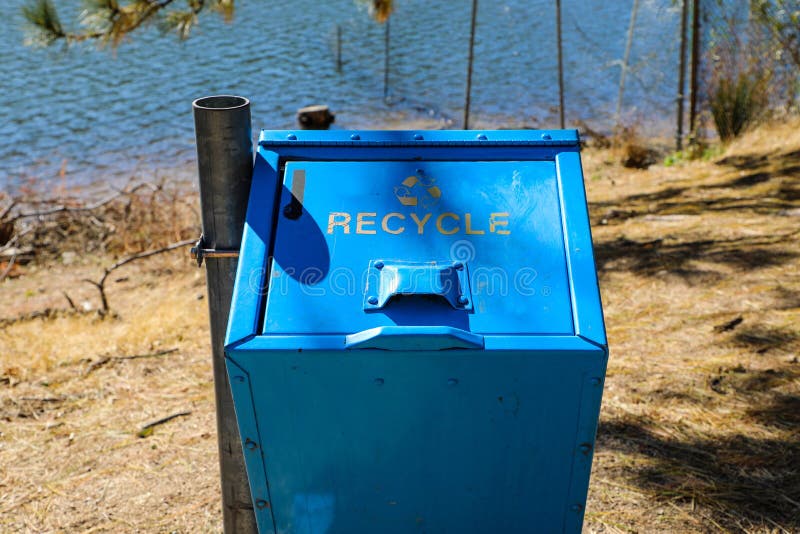 Blue recycle bin along the hiking trail at Lake Gregory in Crestline California. Blue recycle bin along the hiking trail at Lake Gregory in Crestline California