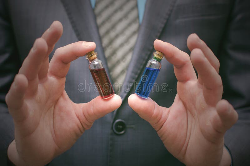 Blue and red pill essential liquid in business man hands. Right choice of medicaments.