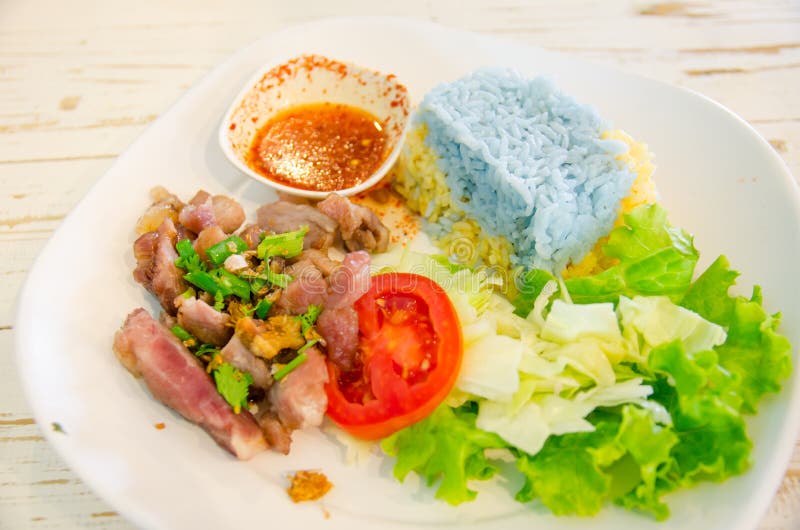 Blue rice with roasted pork stock photos