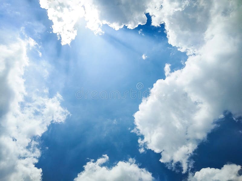Blue skies with clouds passing through the sun. stock photo