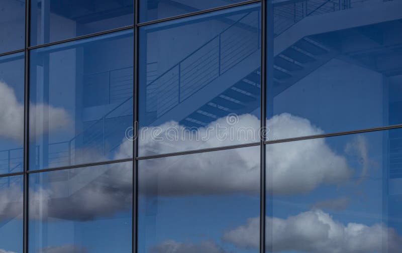 Blue sky and clouds reflection in office building window