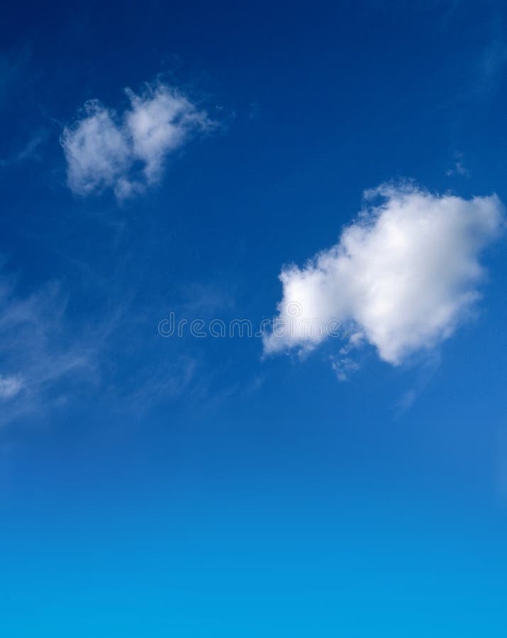 Einen blauen Himmel mit flaumigen weißen Wolken.