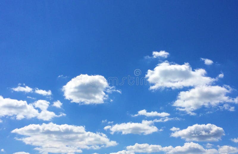 Blue sky and white puffy clouds stock image