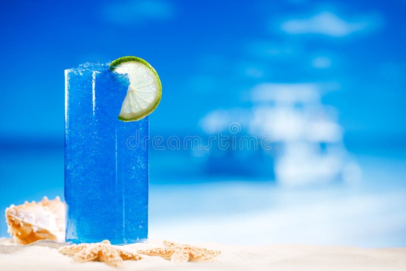 Blue slush ice drink in glass with seascape