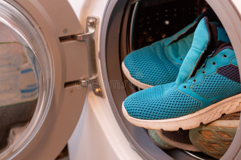 Blue sneakers into washing machine, automatic washing machine. Automatic loading stock images, royalty-free photos and pictures