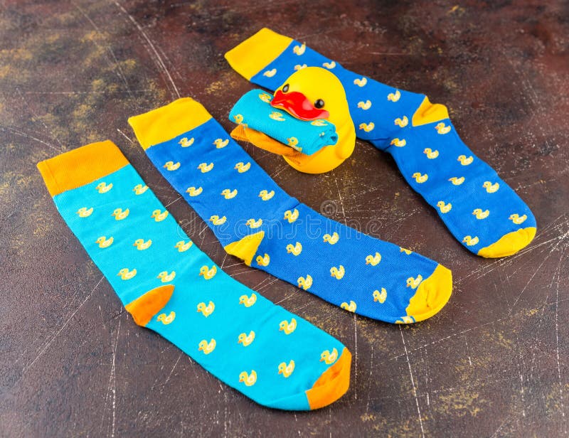 Blue socks with a pattern of yellow ducks stock photos