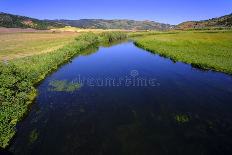 Blue Stream or River Flowing in Valley Reflecting Blue Sky and Clouds Stock Image Image of
