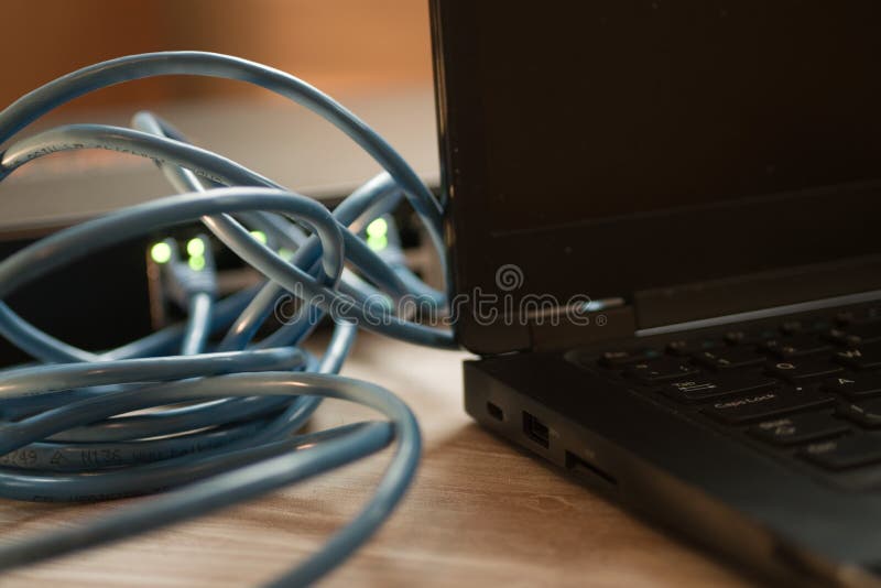 Blue USB Wires Behind the Black Laptop on the Table Stock Photo - Image