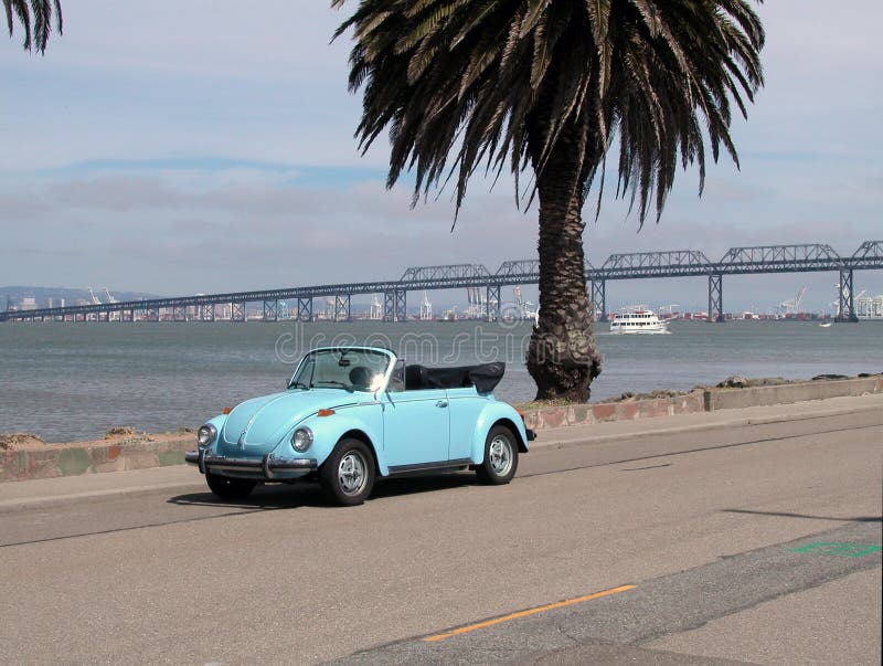 Blue VW convertible by bay