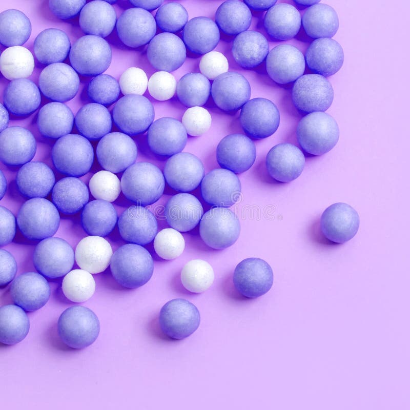 Blue and White Balls are Scattered on the Lilac Surface Stock Photo