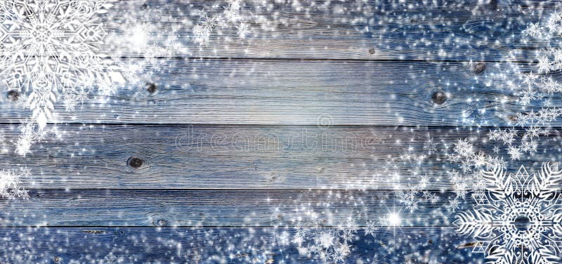 Blue winter wooden background with snowflakes around. Christmas, New Year card with copy space in the center