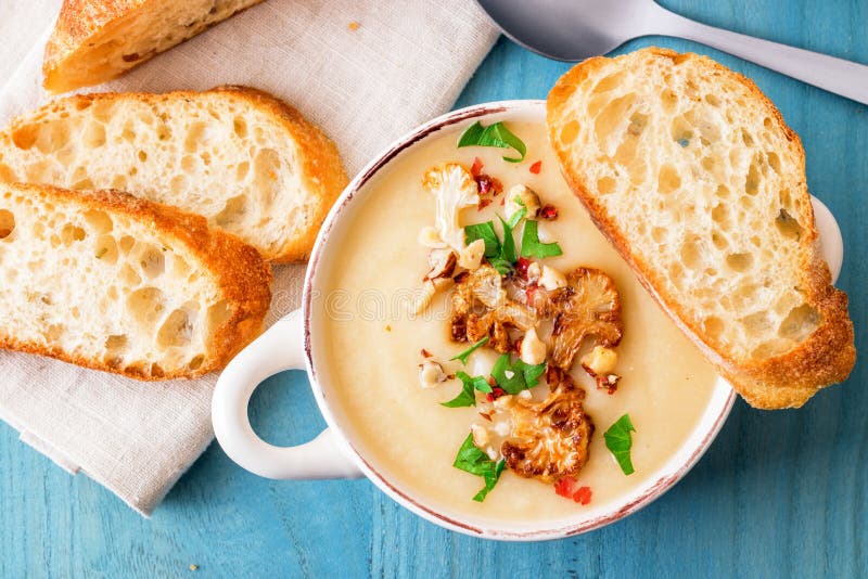 Cauliflower creamy soup with hazelnuts, red pepper and parsley