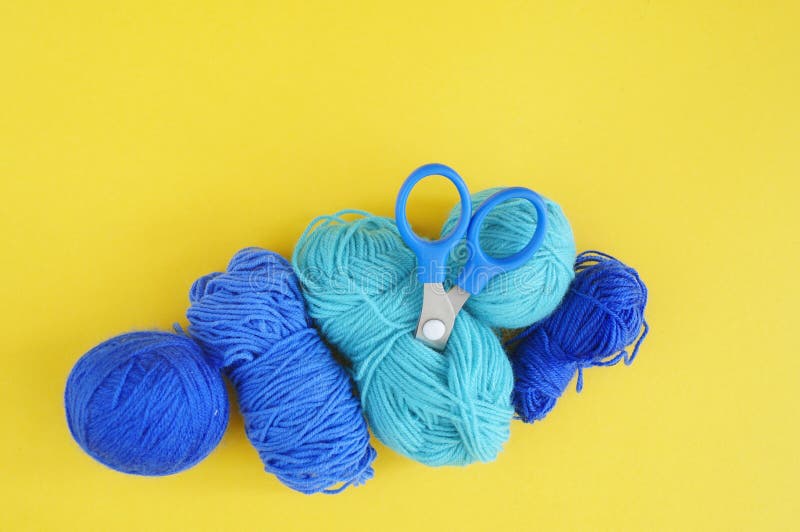 Blue Woolen Threads. Tangles of Thread,scissors and a Knitted Scarf