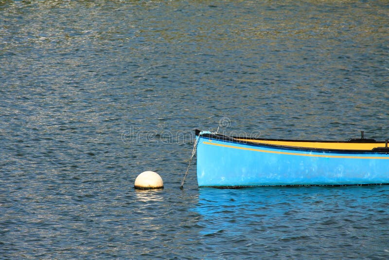 Blue yellow kayak canoe floating in harbor isolated royalty free stock photography