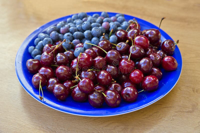 Blueberries and Cherries Lay on Blue Plate Stock Photo Image of diet