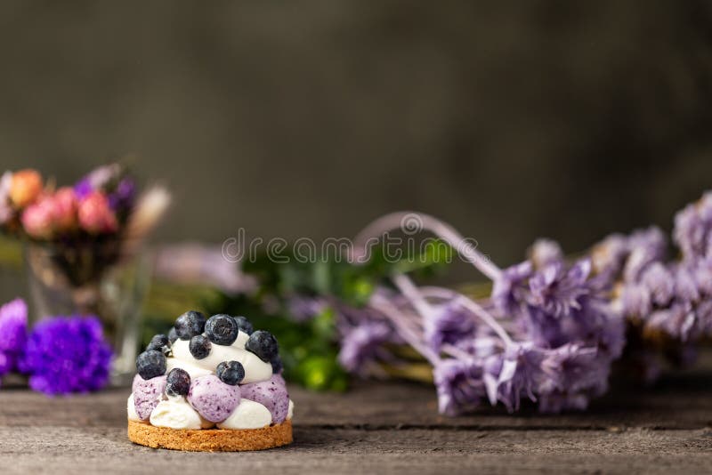 Blueberry Graham Cheesecake topped with fresh berries on dark wood vintage table over a dry flowers background stock image Blueberry Graham Cheesecake topped with fresh berries on dark wood vintage table over a dry flowers background stock image