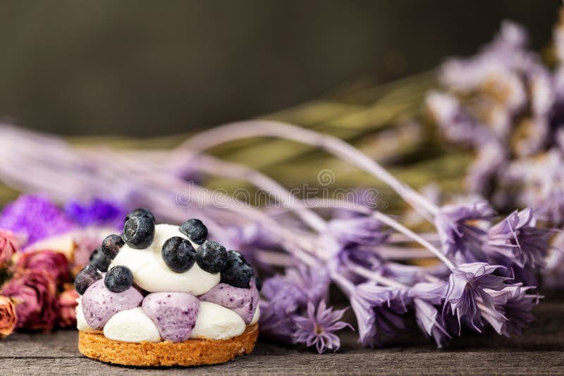 Blueberry Graham Cheesecake topped with fresh berries on dark wood vintage table over a dry flowers and twigs background royalty free stock image Blueberry Graham Cheesecake topped with fresh berries on dark wood vintage table over a dry flowers and twigs background royalty free stock image