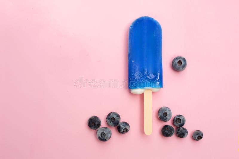 Blueberry popsicle with fresh blueberry on a pink background. Blueberry popsicle with fresh blueberry on a pink background