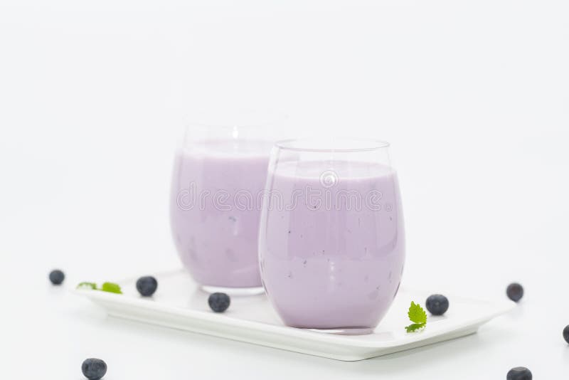 Blueberry smoothie with fresh blueberries on light background. Healthy summer drink. Vegetarian dessert.