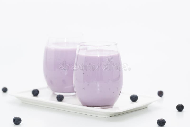 Blueberry smoothie with fresh blueberries on light background. Healthy summer drink. Vegetarian dessert.