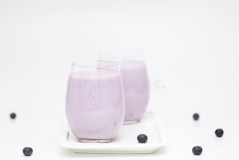 Blueberry smoothie with fresh blueberries on light background. Healthy summer drink. Vegetarian dessert.