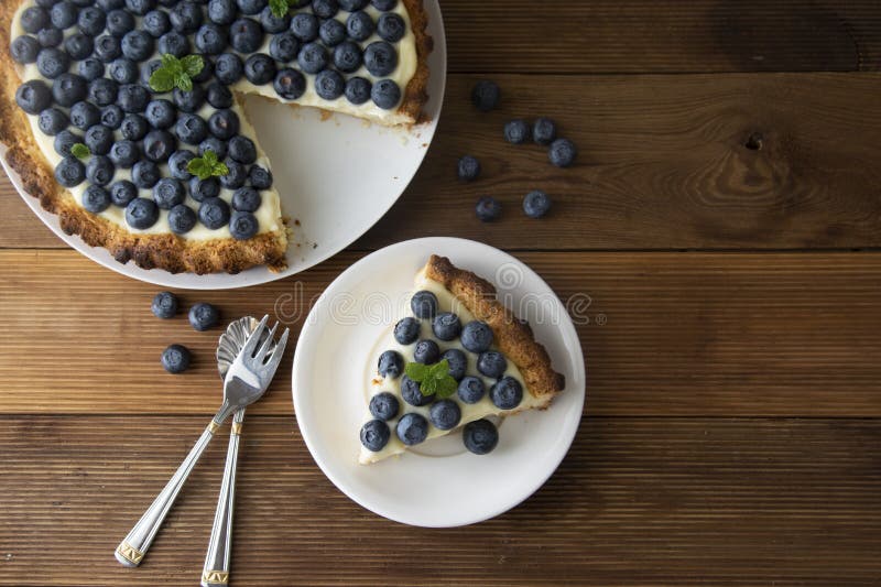 Blueberry Tart. Homemade piece of berry tart, cake with cream. Fresh sweet dessert with fruit. Top view. wooden, rustic background royalty free stock images Blueberry Tart. Homemade piece of berry tart, cake with cream. Fresh sweet dessert with fruit. Top view. wooden, rustic background royalty free stock images